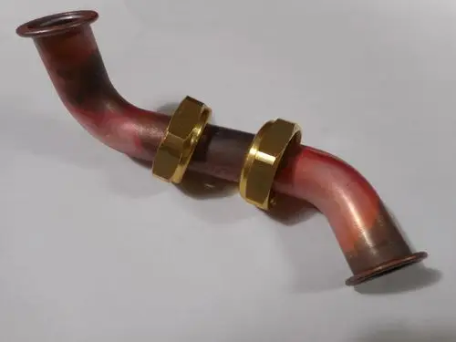 Kupferrohr mit gebogenen Enden und zwei goldfarbenen Gewindemuttern, Hersteller Remeha.